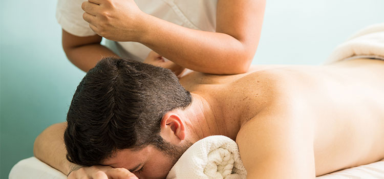 man receiving intense massage from female practitioner elbow