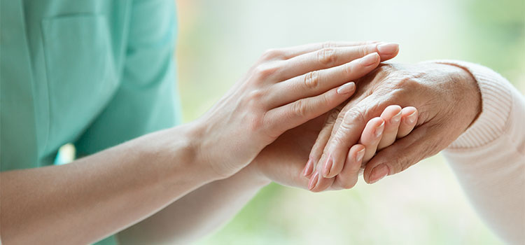 reassuring nurse holding patient hand