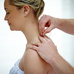 patient eyes closed while acupuncture needles added to shoulders