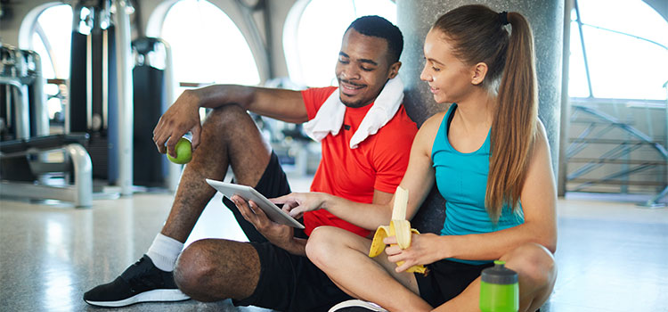 workout partners look at diet plan on tablet