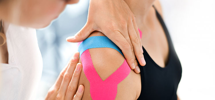athletic trainer tapes female shoulder