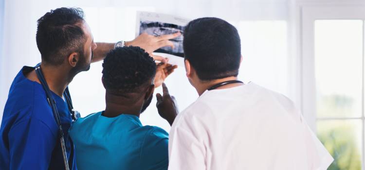 a doctor and his residency students look at an x-ray image together