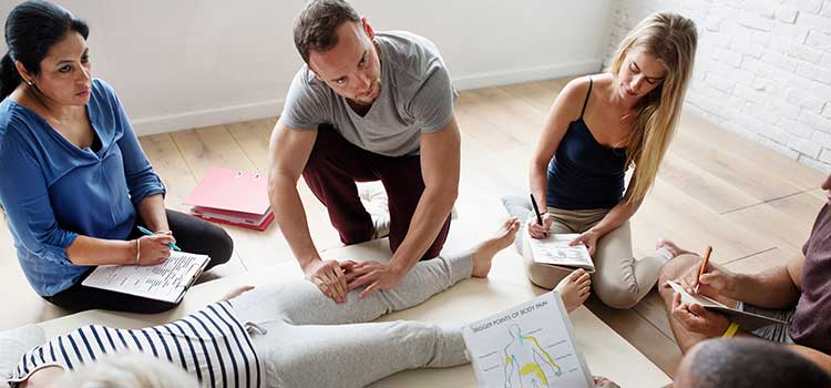 man and women students in massage therapy training class