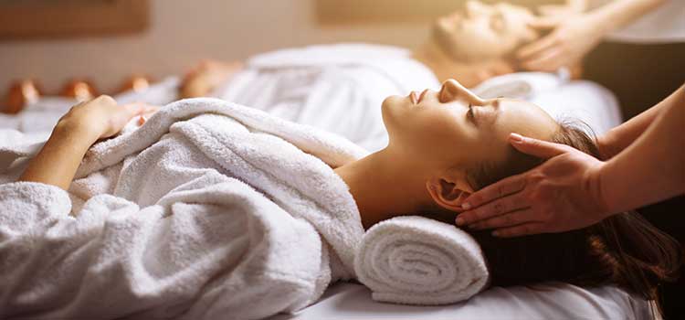 woman having a massage with therapist hands on temples