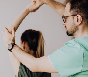 osteopathic doctor lifting patients arm during a session