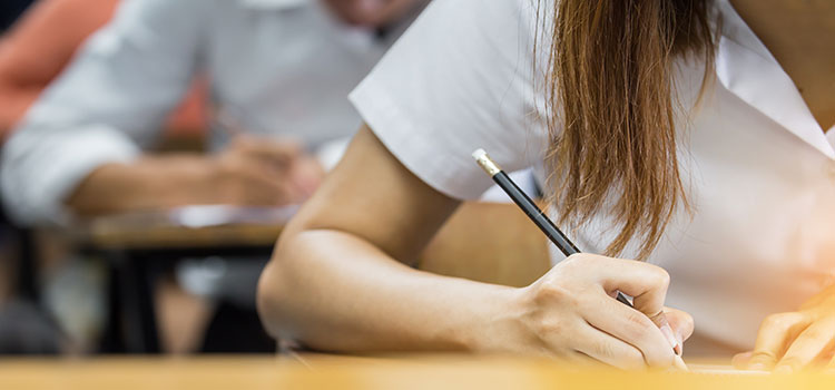 woman with pencil taking written exam