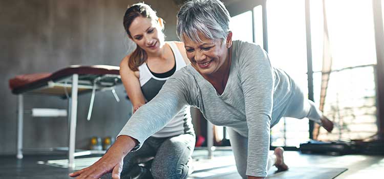 physical therapist working with older woman on core strength