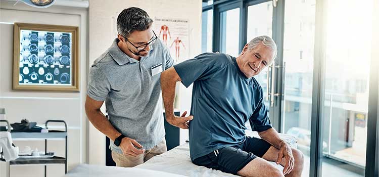 chiropractor works with older man on lower back pain